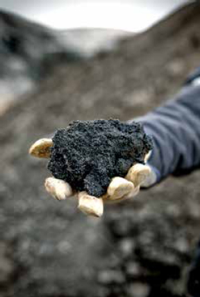 A handful of black oil-rich sand from Alberta, Canada