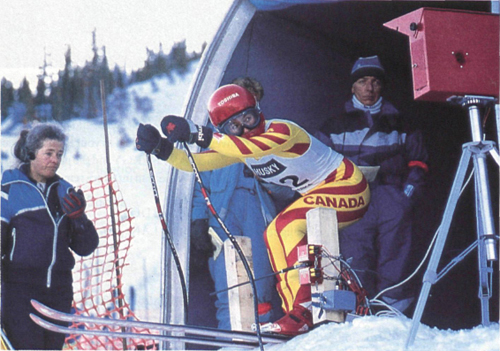 A skier checks the time clock before starting down the slope during a preliminary race at the 1988 Olympic Winter Games