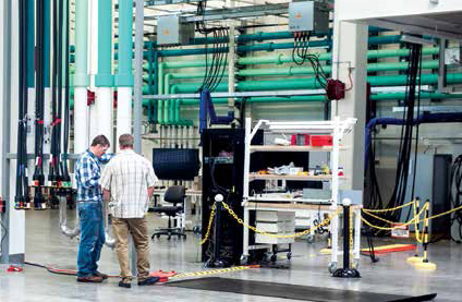 NREL technicians Josh Martin and Scott Walters work in the Power Systems Integration Lab (PSIL) at the ESIF